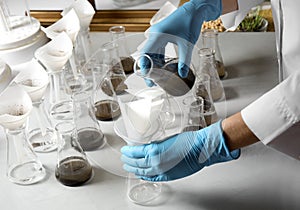Scientist filtering soil samples at table. Laboratory analysis