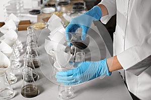 Scientist filtering soil samples at table. Laboratory analysis