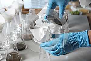 Scientist filtering soil samples at table. Laboratory analysis
