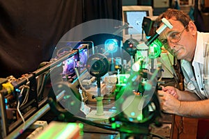 Scientist with glass demonstrate laser photo