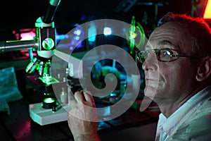 Scientist with glass demonstrate laser photo