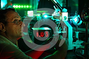 Scientist with glass demonstrate laser photo