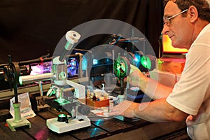 Scientist with glass demonstrate laser photo