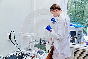 Scientist with gloved hand putting DNA sample into real-time PCR-cycler