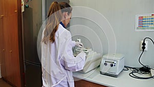 Scientist with gloved hand putting DNA sample into real-time PCR-cycler