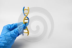 Scientist holding DNA molecule model made of colorful plasticine on white background, closeup. Space for text