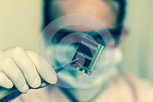 Scientist holding and examining damaged electrical component