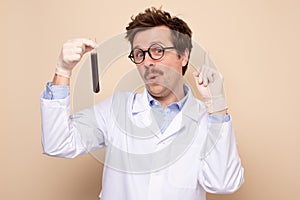 Scientist holding a glass tube with blue fluid being happy he made a great discover.