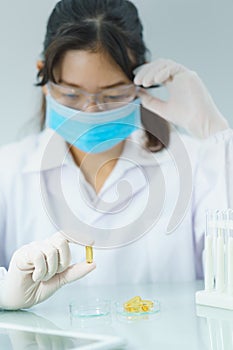 Scientist holding Omega 3 capsule in labcoat