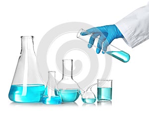 Scientist holding test tube over table with laboratory glassware. Chemical research