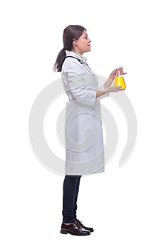 Scientist holding up beaker with of chemical yellow liquid