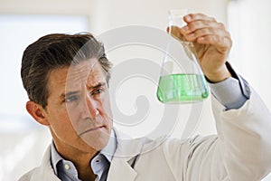 Scientist holding up jar of chemicals