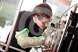 Scientist inserts hand to laser deposition chamber