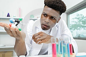 scientist in lab coat holding molecular models