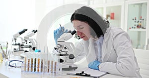 Scientist laboratory assistant checks quality of cereals under microscope