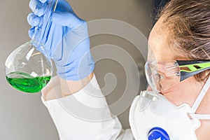 Scientist in laboratory green liquid