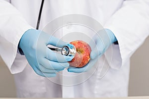 Scientist listening apple with stethoscope