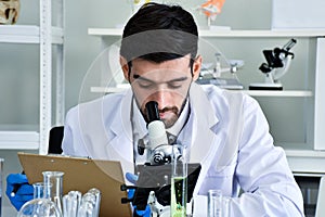 Scientist look at microscopes to study chemical samples in a lab