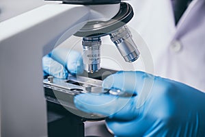 scientist looking through a microscope in a laboratory. Young scientist doing some research