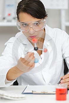 Scientist looking at model dna chain
