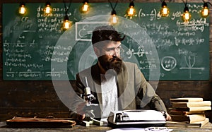 Scientist make research with microscope. Businessman wear glasses at desk. Man with beard and mustache in university