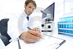 Scientist makes a note of experiment in the laboratory