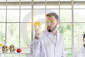 Scientist man working holding medical chemicals sample in experimental bottle in lab room