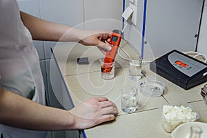 Scientist measuring pH in chemical laboratory using pH-meter in glassware equipment