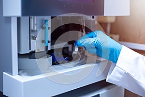 Scientist moved the vial of sample out from the tray autosampler of the Liquid Chromatography Mass Spectrometer LC MS a