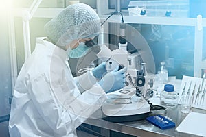 Scientist or nurse looking through a microscope in a Medical Research Laboratory photo