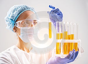 Scientist pouring organic oil. Beauty and cosmetics sciences.