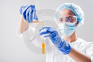 Scientist pouring organic oil. Beauty and cosmetics sciences.