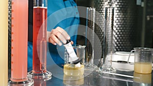 Scientist pouring wine product liquid into test tube, Quality control. winemakers laboratory testing wine in winery lab