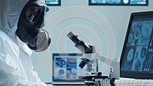Scientist in protection suit and masks working in research lab using laboratory equipment: microscopes, test tubes