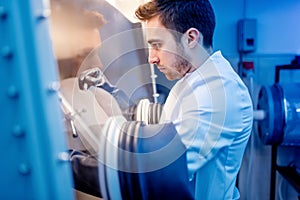 Scientist with protective robber gloves for handling dangerous substances in sterile environment