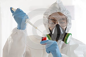Scientist in protective wear with blood sample
