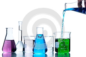 Scientist put blue liquid into measuring beaker  with laboratory glassware