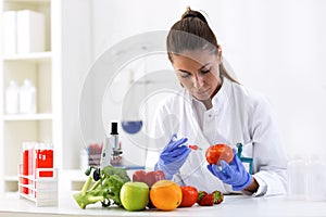 Scientist putting new sample to vegetables and cheking results