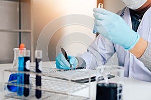 Scientist recording making note on book with his findings test t