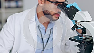 Scientist, research analyst or medical engineer looking through a microscope and recording his findings. Examining DNA