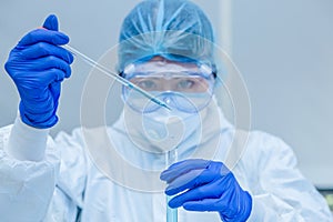 Scientist or researcher hand in blue gloves holding flu, measles, coronavirus, covid-19 vaccine disease