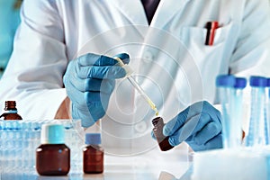 Scientist or researcher medical holding test tube and dropping reagent in the biochemistry lab