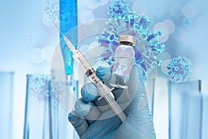 The scientist`s hand holding the Covid-19 vaccine with blue gloves in the background of the biotechnology concept