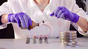 The scientist`s hands pouring solvent into the bottles