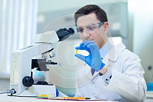 Scientist studies properties and benefits of omega 3 fatty acids using microscope and laboratory equipment in a medical