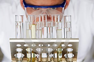 Scientist Studying Test Tubes In Rack