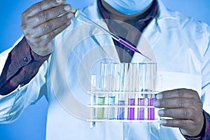 Scientist taking color solution in a test tube