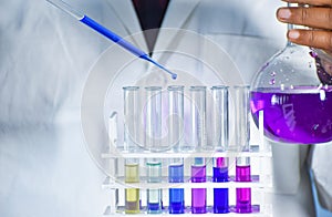 Scientist taking color solution in a test tube