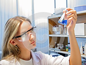 Scientist with test tubes and flasks conducting an experiment in a science lab