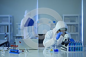 Scientist using microscope during experiment in laboratory, Science and technology healthcare concept